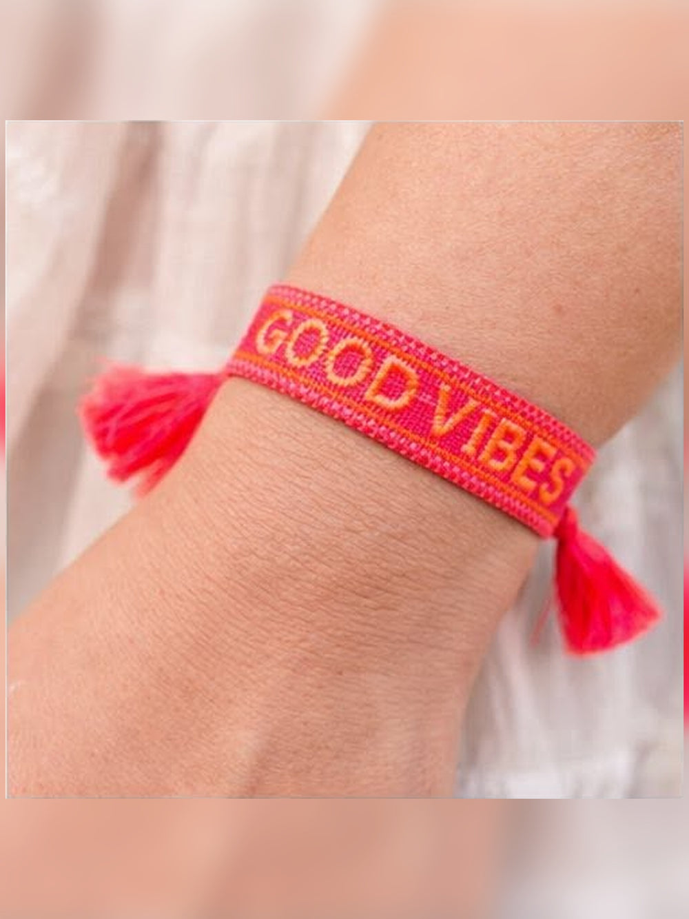 Boho Armband Good Vibes am Handgelenk – pinkes Webband mit orangefarbenem Schriftzug und zwei Quasten, Modeschmuck von CurvyRausch