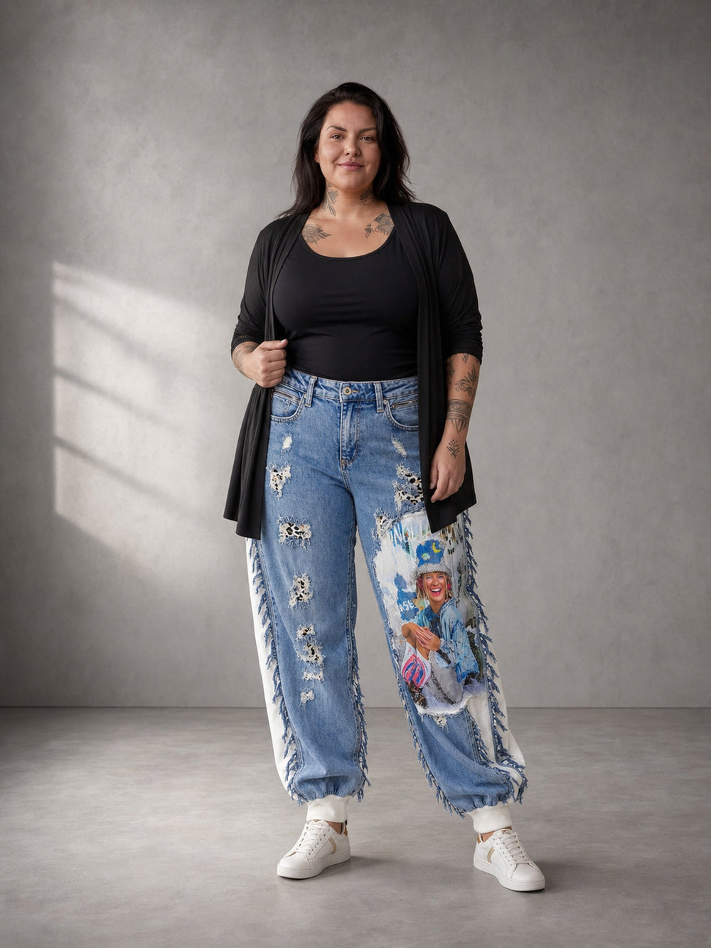 Jeans-Jogger Vegas Glam Modell Las Vegas Leo getragen – Curvy Model in Ganzkörperansicht, blauer Fotoprint am rechten Bein, dazu schwarzes Top und langer Cardigan, in großen Größen von CurvyRausch