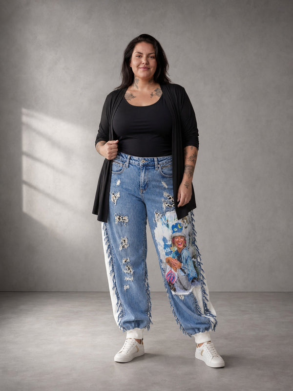Jeans-Jogger Vegas Glam Modell Las Vegas Leo getragen – Curvy Model in Ganzkörperansicht, blauer Fotoprint am rechten Bein, dazu schwarzes Top und langer Cardigan, in großen Größen von CurvyRausch