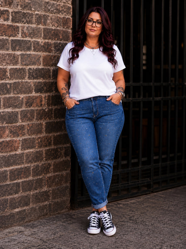 Momfit Jeans Star Glamour in Jeansblau, getragen zu weißem T-Shirt und schwarzen Sneakern – Nieten- und Strassdekor auf dem Vorderteil, große Größen von CurvyRausch