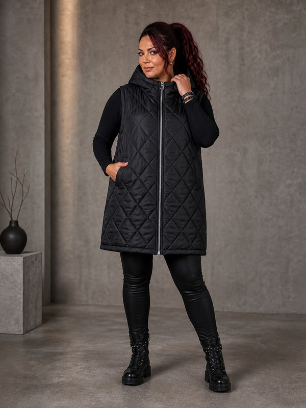 Curvy Model in schwarzer Steppweste Heart Hunter, geschlossen getragen mit Kapuze, Lederleggings und Boots, in großen Größen von CurvyRausch